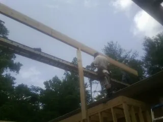Carpenter setting a ridge beam over a new addition frame — Ice Dam Removal by Roofing Brothers in Elmwood Park