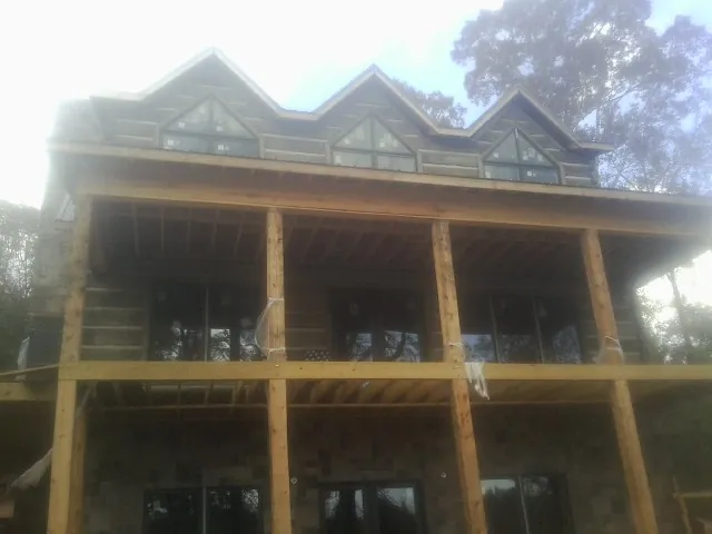Dormers and porch framing on a large log home under construction — Roof Coating work by our crew in Elmwood Park