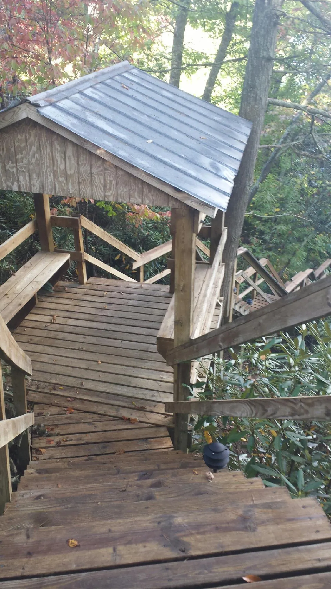 Metal roofed shelter over wooden steps on a wooded walkway — Skylight Repair & Installation work by our crew in Elmwood Park